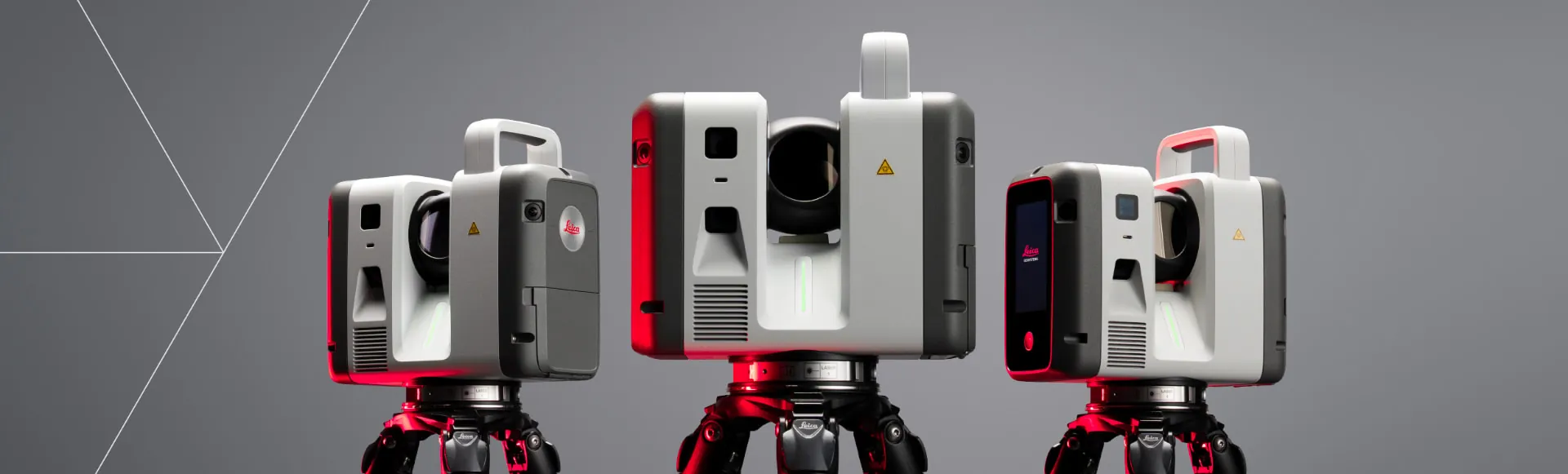 Tre Leica RTC-laserskannere på stativ mot grå bakgrunn